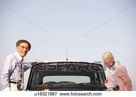 Stock Photo - Senior couple standing next to a car. Fotosearch