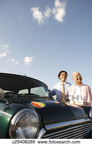 Senior couple standing next to a car View Large Photo Image Stock Photo - Senior couple standing next to a car. Fotosearch