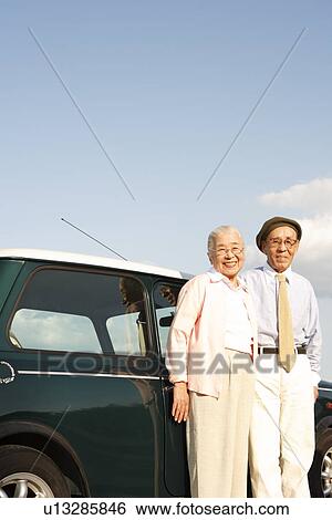 Senior couple standing next to a car View Large Photo Image Stock Photograph - Senior couple standing next to a car. Fotosearch