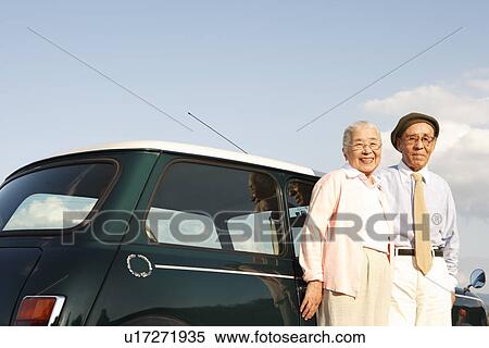 Stock Photography - Senior couple standing next to a car. Fotosearch