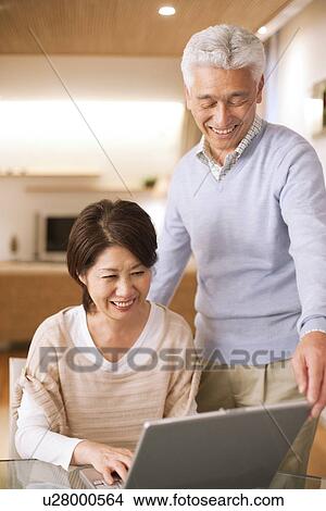 Picture - Senior couple using laptop, smiling. Fotosearch
