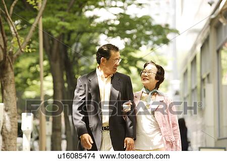 Senior couple walking arm in arm, smiling View Large Photo Image Picture - Senior couple walking arm in arm, smiling. Fotosearch
