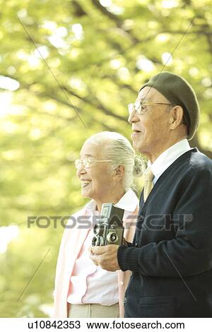 Stock Image - Senior couple with vintage camera. Fotosearch