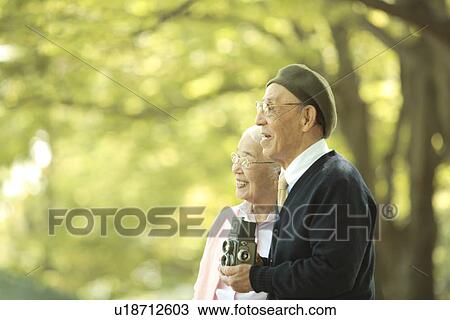 Stock Image - Senior couple with vintage camera. Fotosearch