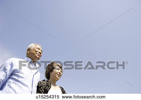 Senior man and mature woman standing under blue sky, copy space View Large Photo Image Stock Photography - Senior man and mature woman standing under blue sky, copy space. Fotosearch