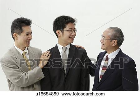 Stock Photo - Senior Man and Mid Adult Man Patting on Young Man's Shoulder. Fotosearch