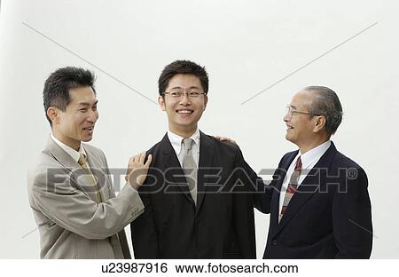 Stock Photograph - Senior Man and Mid Adult Man Patting on Young Man's Shoulder. Fotosearch
