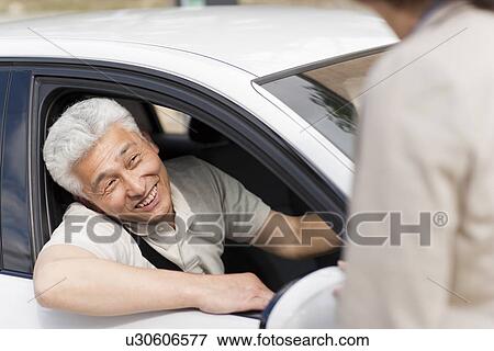 Stock Photo - Senior man in car, smiling. Fotosearch