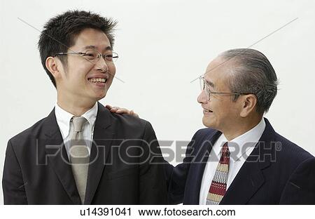 Stock Image - Senior Man Patting on Young Man's Shoulder. Fotosearch