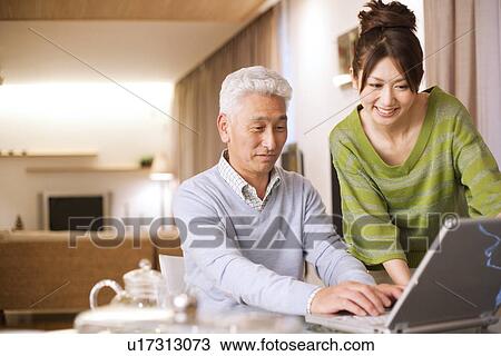 Senior man with daughter using laptop, smiling View Large Photo Image Stock Image - Senior man with daughter using laptop, smiling. Fotosearch