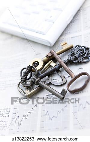 Stock Image - Stack of keys on newspaper, close up. Fotosearch