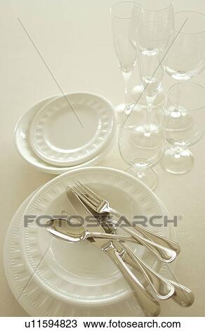 Stock Image - Still life of plates, wineglasses and silverware. Fotosearch