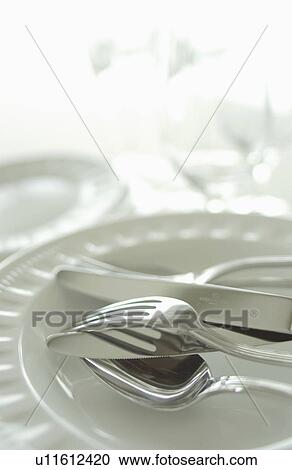 Stock Image - Still life of plates, wineglasses and silverware. Fotosearch
