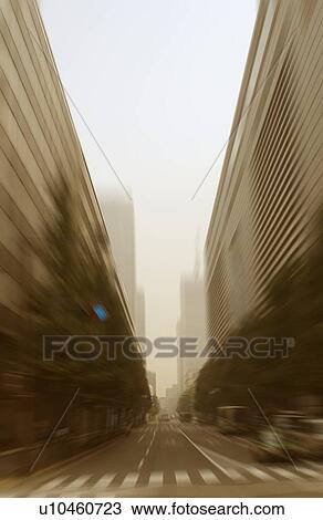 Stock Image - Street in city, sepia toned, blurred motion. Fotosearch
