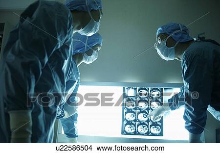 Picture - Surgeons discussing X-rays. Fotosearch