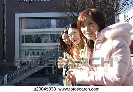 Stock Photo - Three young women on footbridge, Tokyo Prefecture, Honshu, Japan. Fotosearch
