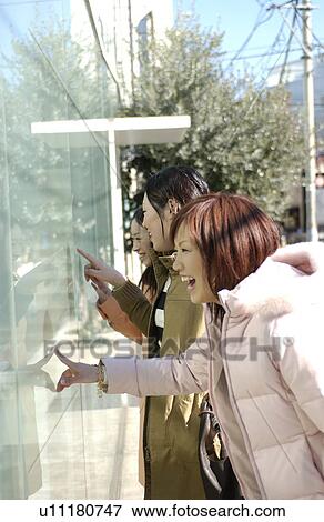 Three young women window shopping View Large Photo Image Stock Photo - Three young women window shopping. Fotosearch