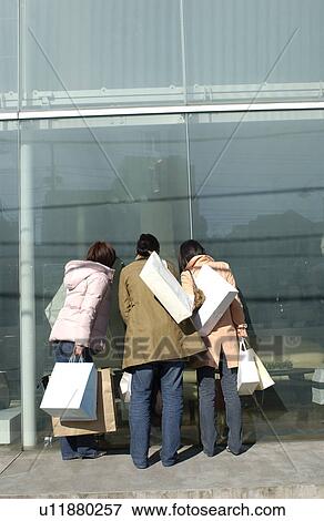 Three young women window shopping View Large Photo Image Stock Photo - Three young women window shopping. Fotosearch