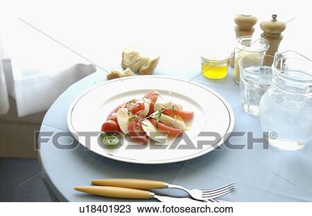 Tomatoes, mozzarella and basil salad on dining table View Large Photo Image Stock Image - Tomatoes, mozzarella and basil salad on dining table. Fotosearch