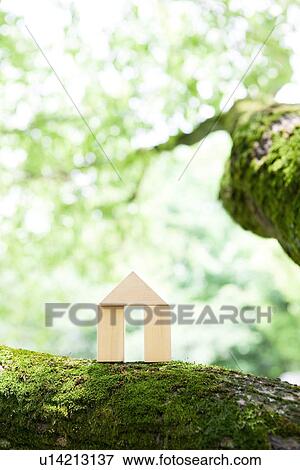 Stock Photo - Toy wooden house on tree trunk. Fotosearch