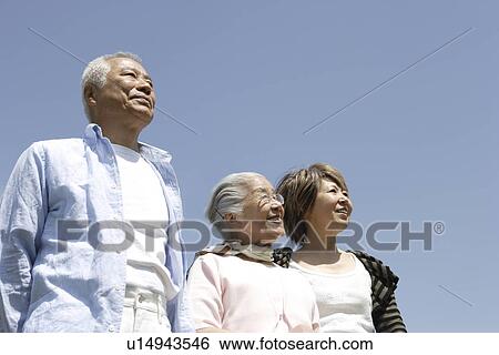 Two generation family against sky, smiling, blue background View Large Photo Image Stock Photograph - Two generation family against sky, smiling, blue background. Fotosearch