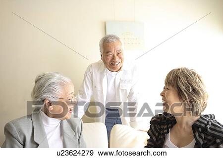 Stock Photo - Two generation family in living room, smiling. Fotosearch