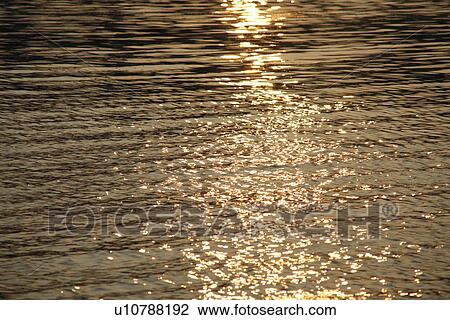 Stock Image - Water surface in the evening, sepia toned, full frame. Fotosearch