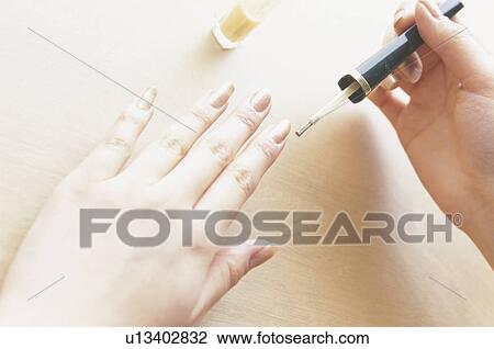Stock Image - Woman painting fingernails. Fotosearch