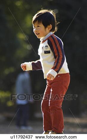 Stock Photo - Young boy standing, side view, Tokyo Prefecture, Honshu, Japan. Fotosearch