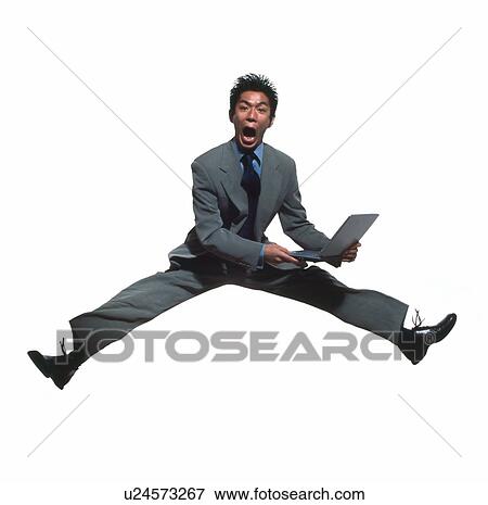 Young businessman jumping with laptop View Large Photo Image Stock Photo - Young businessman jumping with laptop. Fotosearch