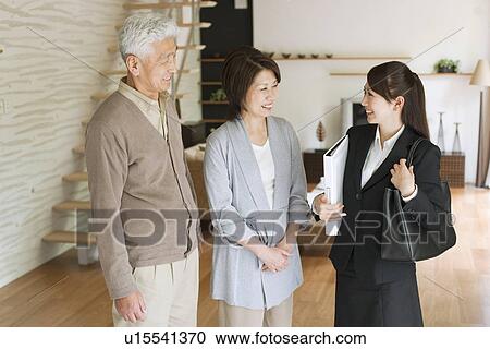 Young businesswoman and senior couple in living room, smiling View Large Photo Image Stock Image - Young businesswoman and senior couple in living room, smiling. Fotosearch