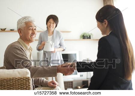 Young businesswoman and senior man shaking hands, smiling View Large Photo Image Stock Photo - Young businesswoman and senior man shaking hands, smiling. Fotosearch