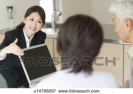 Young businesswoman showing computer monitor to senior couple View Large Photo Image Stock Photo - Young businesswoman showing computer monitor to senior couple. Fotosearch