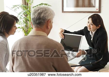 Young businesswoman showing computer monitor to senior couple View Large Photo Image Stock Photo - Young businesswoman showing computer monitor to senior couple. Fotosearch