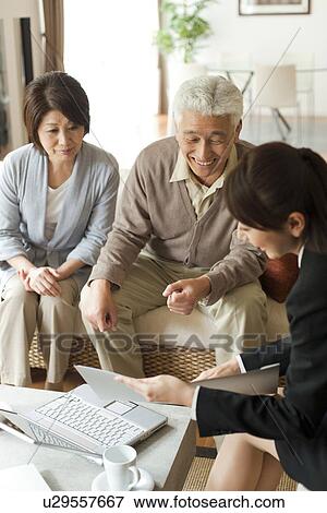 Young businesswoman showing file to senior couple View Large Photo Image Stock Photo - Young businesswoman showing file to senior couple. Fotosearch