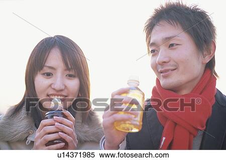 Young couple drinking bottled tea View Large Photo Image Stock Photography - Young couple drinking bottled tea. Fotosearch