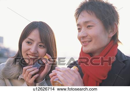 Young couple holding bottled tea View Large Photo Image Picture - Young couple holding bottled tea. Fotosearch