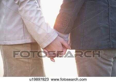 Stock Image - Young couple holding hands. Fotosearch