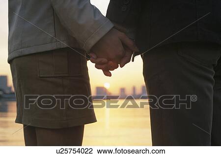 Young couple holding hands View Large Photo Image Stock Image - Young couple holding hands. Fotosearch