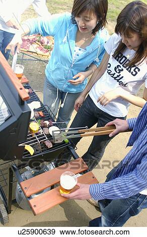 Stock Photo - Young People Doing BBQ. Fotosearch