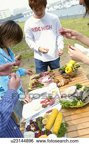 Stock Photograph - Young People Doing BBQ. Fotosearch