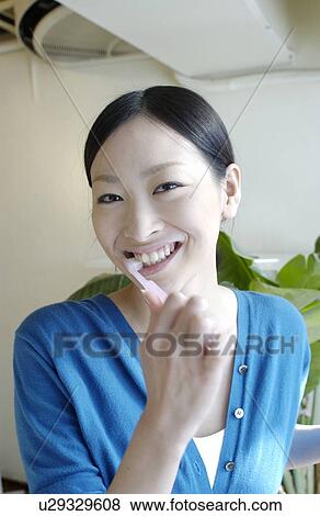 Stock Photo - Young woman brushing teeth. Fotosearch