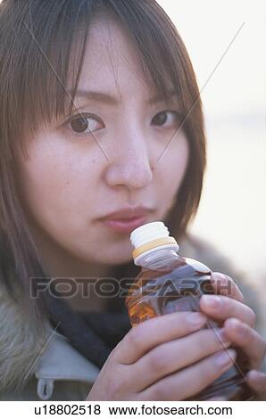Young woman drinking bottled tea View Large Photo Image Stock Photo - Young woman drinking bottled tea. Fotosearch
