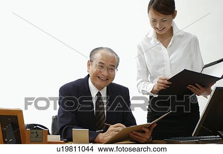 Picture - Young Woman Executive Assistant and Her Boss at Office. Fotosearch