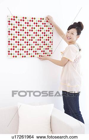 Young woman hanging fabric on wall View Large Photo Image Picture - Young woman hanging fabric on wall. Fotosearch