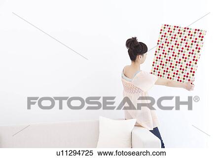 Young woman hanging fabric on wall View Large Photo Image Stock Photography - Young woman hanging fabric on wall. Fotosearch
