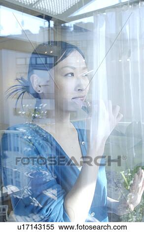Young woman looking out the window View Large Photo Image Stock Photography - Young woman looking out the window. Fotosearch