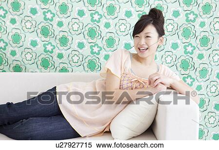 Young woman lying on a couch View Large Photo Image Stock Photography - Young woman lying on a couch. Fotosearch
