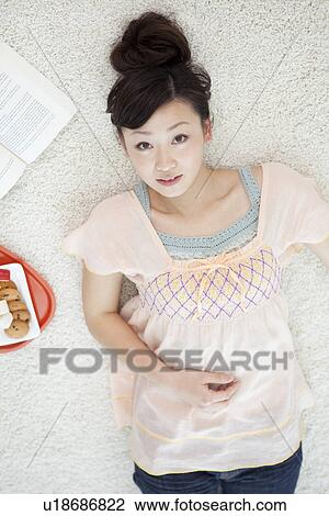 Stock Image - Young woman lying on back. Fotosearch
