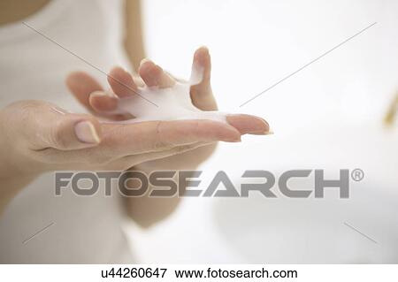 Stock Photo - Young woman making soap suds with hands, close up. Fotosearch